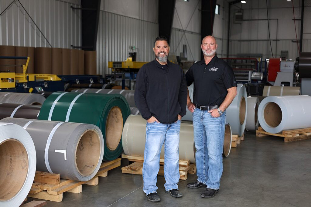 Metal America founders Shawn and Justin stand in from or steel rolls at the Post Falls manufacturing facility