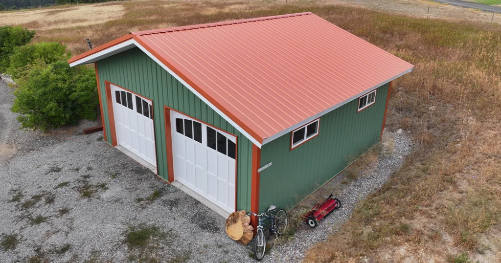 A metal buildings has colored metal roof panels. This green shop has a red metal roof