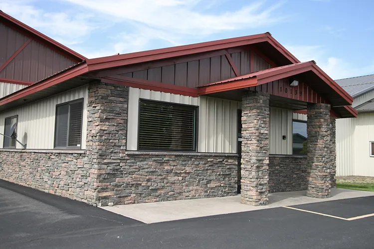 A commercial building with red and white metal siding and roof to match branding colors