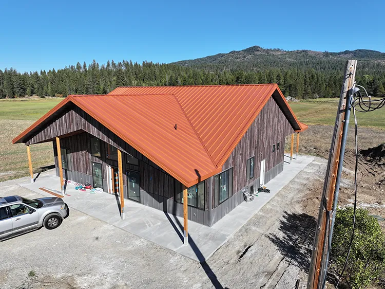 A home with wood look metal siding and an orange metal roof