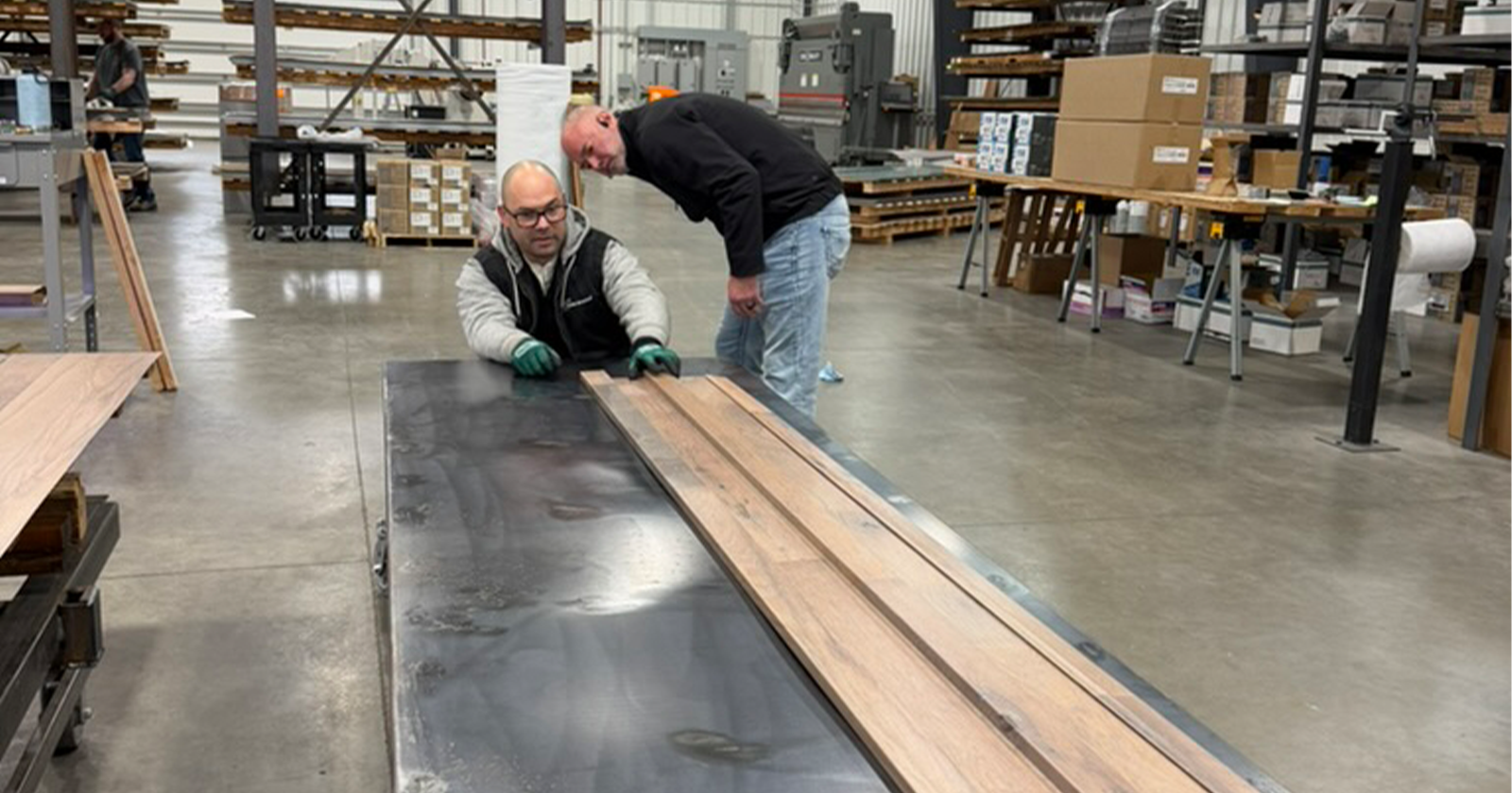 The metal roofing gauge is check by two Metal America employees looking at the steel roofing panel thickness