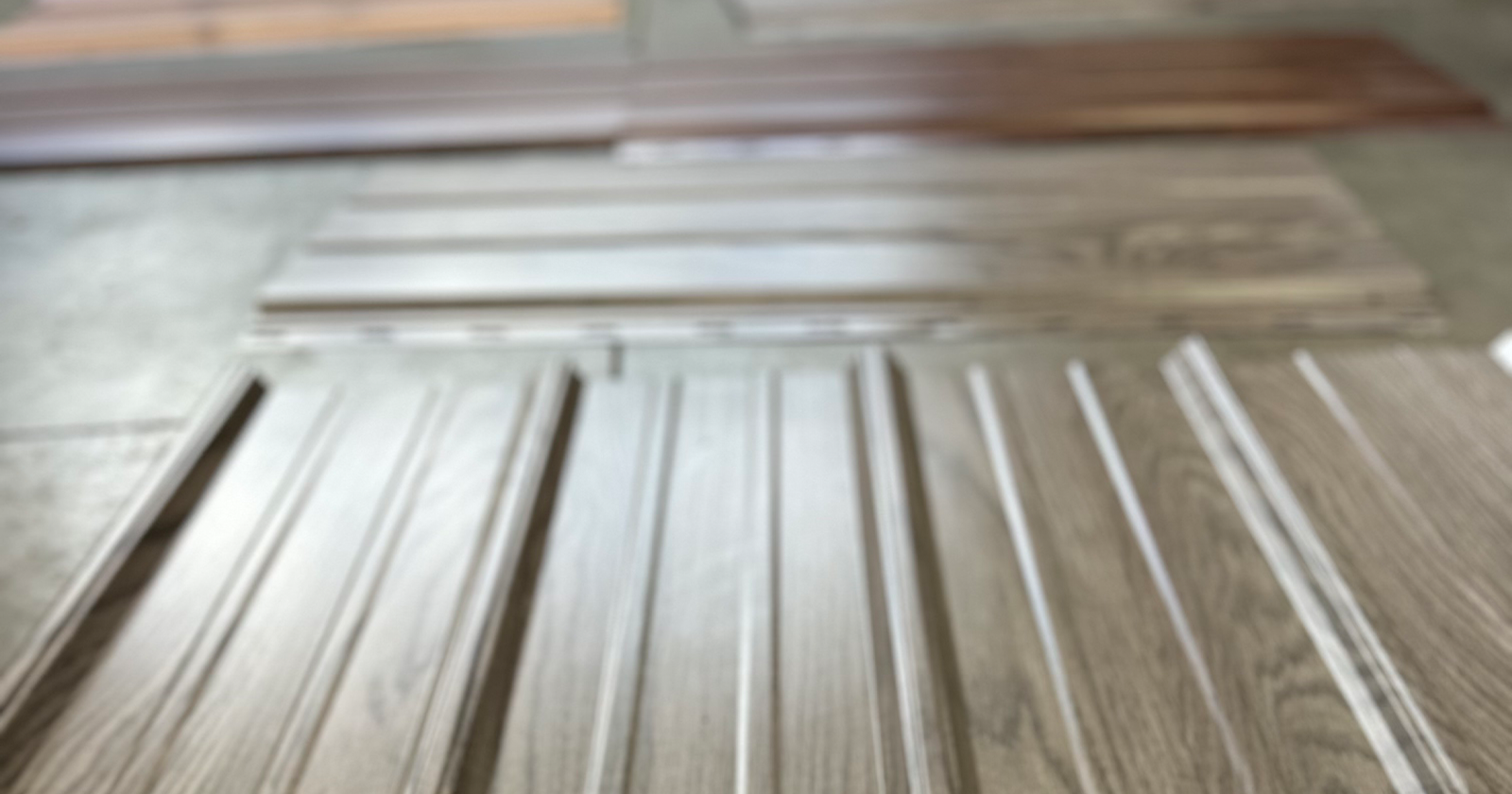 Metal siding panels are laid out on a table top at Metal America