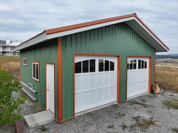 A metal garage features two tone coordinated green and orange metal roofing and siding