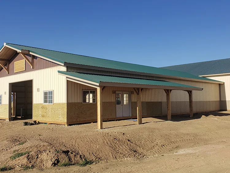 An agricultural building with a green metal roof