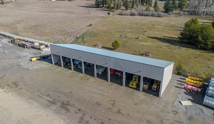 A grey metal roof covers this farm equipment storage building
