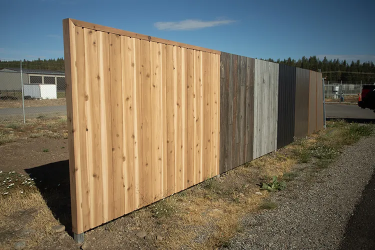 A display of current metal fences with a wood finish that are offered instead of wood fences