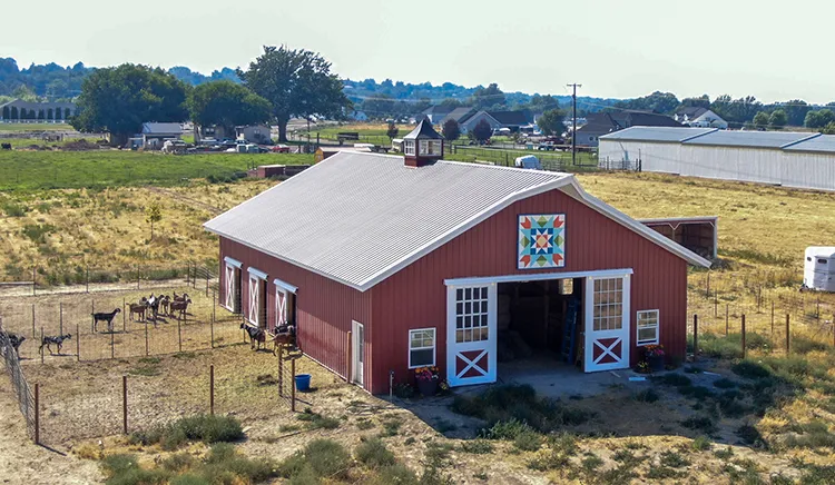 An agricultural building in red with a grey metal roof
