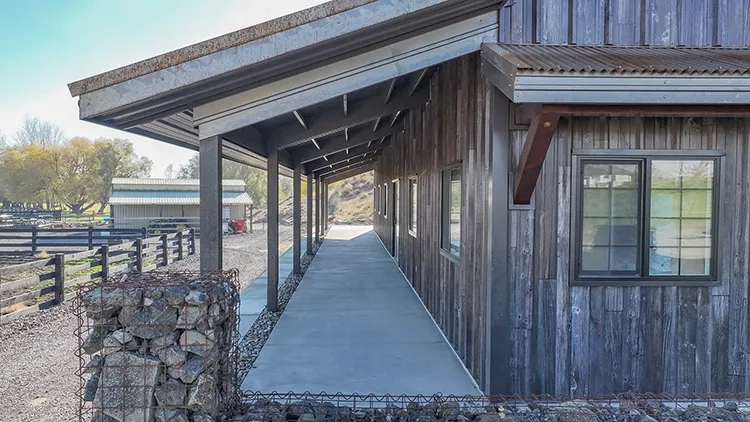 The siding on a modern farmhouse is metal bu tmade to look like aged wood