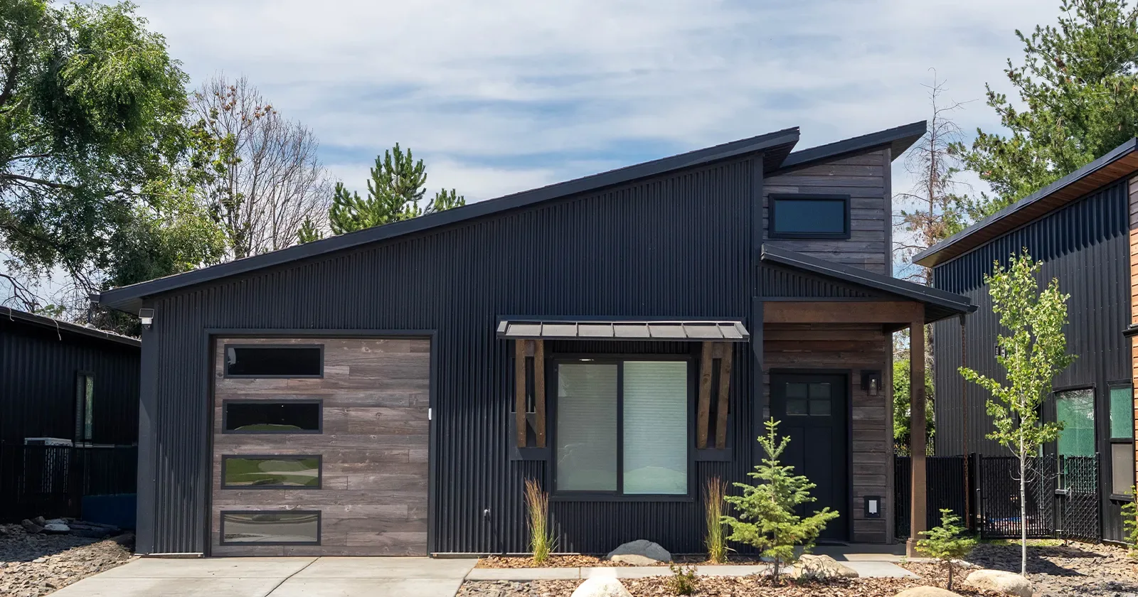 Monitor style shop with wood look metal siding and steel garage doors on the front elevation