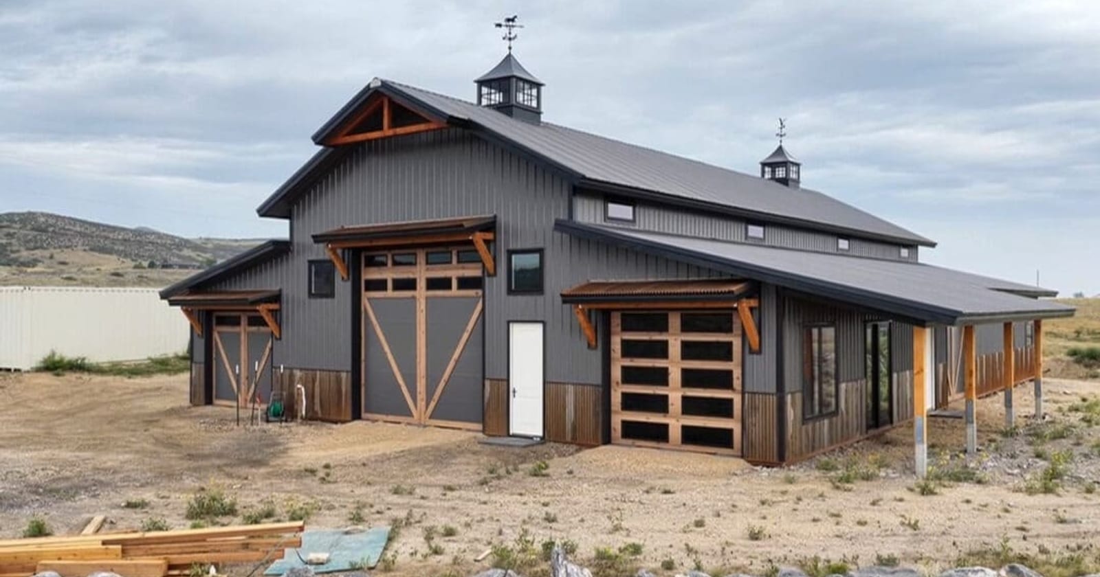 A home with a dark metal roof, the classic look 5V steel roofing panels for farmhouse and cabin roofs deliver