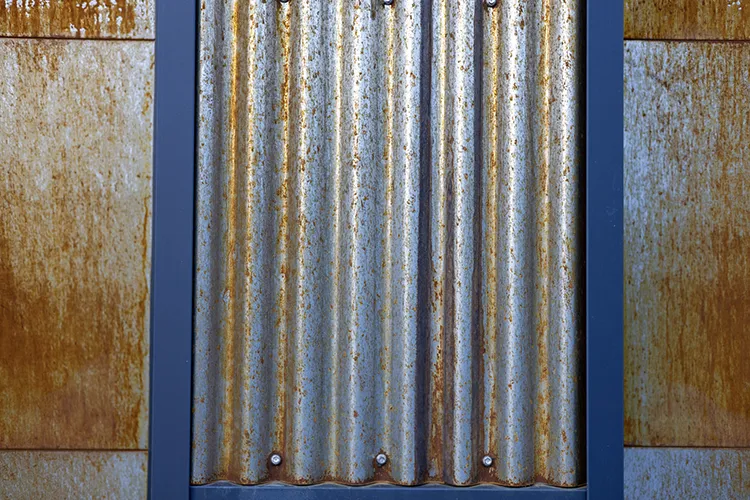 Cor-Ten corrugated metal siding weathered to a rust finish on a building wall