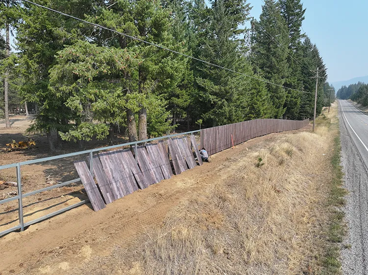 Installing a wood look steel panel, showing how a non combustible fence goes together