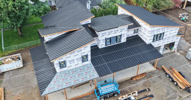 Metal roofing panels stacked at a half finished building, ready for steel roofing contractors near me