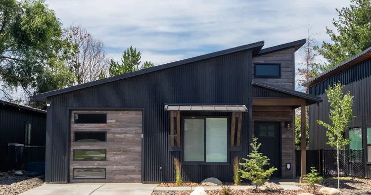 A black home clad in corrugated steel, an example of non combustible siding on a residence