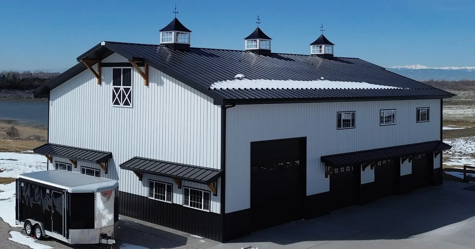 A modern farmhouse clad in white steel siding, a residential use of steel siding for houses