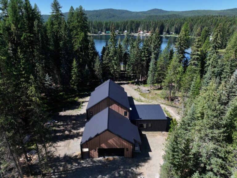 Aerial view of a Smooth Cedar and Gun Metal barndominium among the trees
