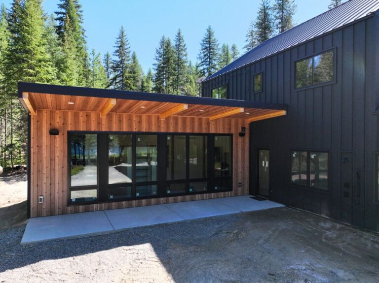 Smooth Cedar wood-look steel siding next to black accents on a modern barndominium