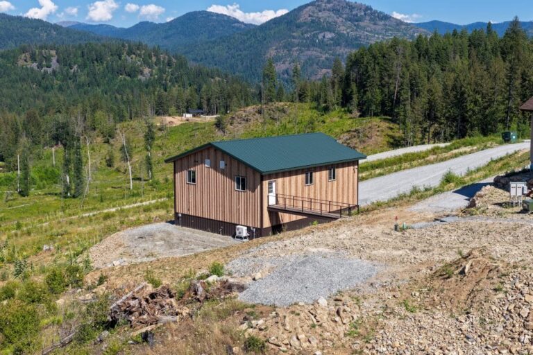 Aerial view of a Smooth Cedar shop with a covered porch and Fern Green metal roof